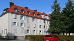 Teil einer sanierten Gebäudezeile, Altbau, 4 Etagen, Klappläden. Rechts zwei hohe Bäume, Parkplatz. Teil einer sanierten Gebäudezeile, Altbau, 4 Etagen, Klappläden. Rechts zwei hohe Bäume, Parkplatz.