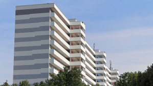 Hochhaus mit weiß-grau gestreifter Fassade und Aufzugstürmen von der Seite Hochhaus mit weiß-grau gestreifter Fassade und Aufzugstürmen von der Seite