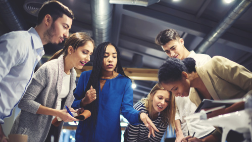 Azubi Junge Erwachsene um ein Tisch versammelt am arbeiten