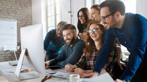 Azubi Junge Menschen lachend um einen Computer