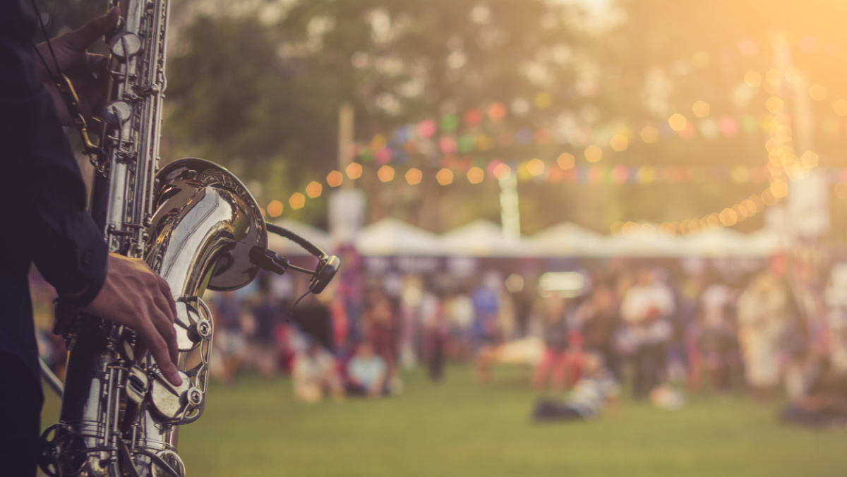 Sicht von Bühne auf Rasen mit Menschen und Instrument