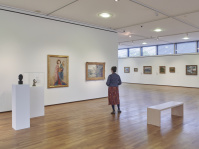 Besucherin im Innenraum der Modernen Galerie, Kunstwerke an den Wänden, Präsentation der Exponate in Säulen und Ruhebank