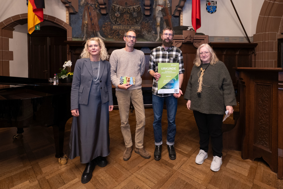 Max-Ophüls Schule Preisübergabe an die Max Ophüls Schule. Zu sehen sind zwei Betreuer der Schule die die Urkunde halten, sowie zwei Jurymitglieder.