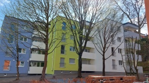 Gebäude mit vier Wohnetagen mit blauer und grüner Fassade Gebäude mit vier Wohnetagen mit blauer und grüner Fassade
