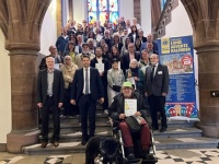 Mehrere Personen stehen auf einer Treppe, daneben befindet sich ein Banner.
