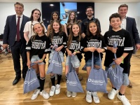 Sportlerehrung 2025 Jungendtanzgruppe steht in Trikots mit ihren Erinnerungsgeschenken vorne. Dahinter stehen Erwachsene, wie der Oberbürgermeister und weitere, wohlmöglich Trainer