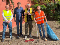 Menschen mit Warnwesten und Müllsäcken