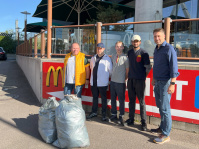 Menschen mit Warnwesten und Müllsäcken