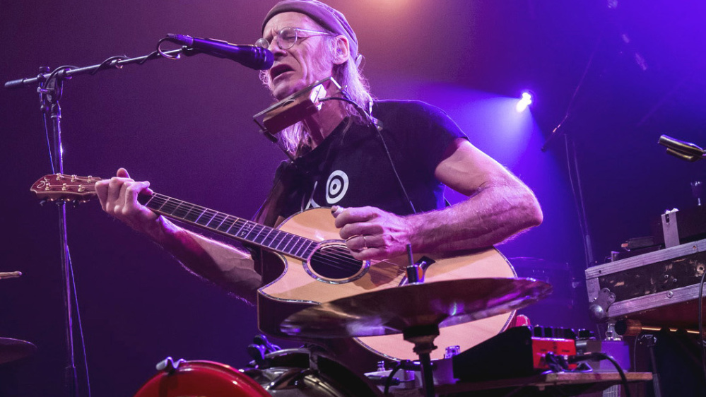 Philippe Ménard  Ein Mann am Schlagzeug und Gitarre in der Hand