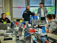 Ein Einsatzraum mit vielen Computern an denen Experten von der Feuerwehr sitzen.